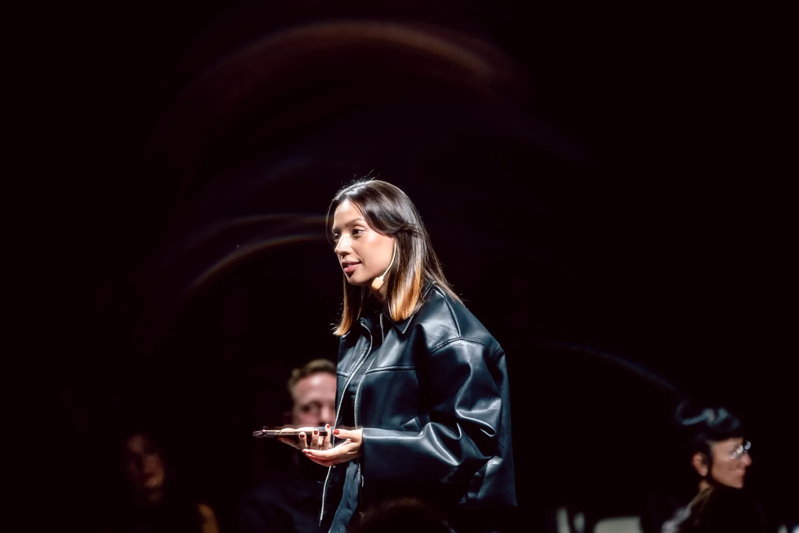 Nicole Boman in profile on a dark stage